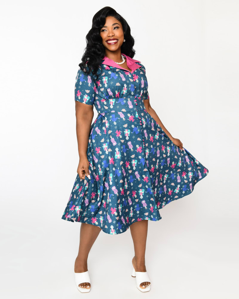Front of a model wearing a size 2X The Golden Girls x Unique Vintage Plus Size Teal & Pink All Over Print Swing Dress in Teal & Pink Golden Girls Print by Unique Vintage. | dia_product_style_image_id:325129